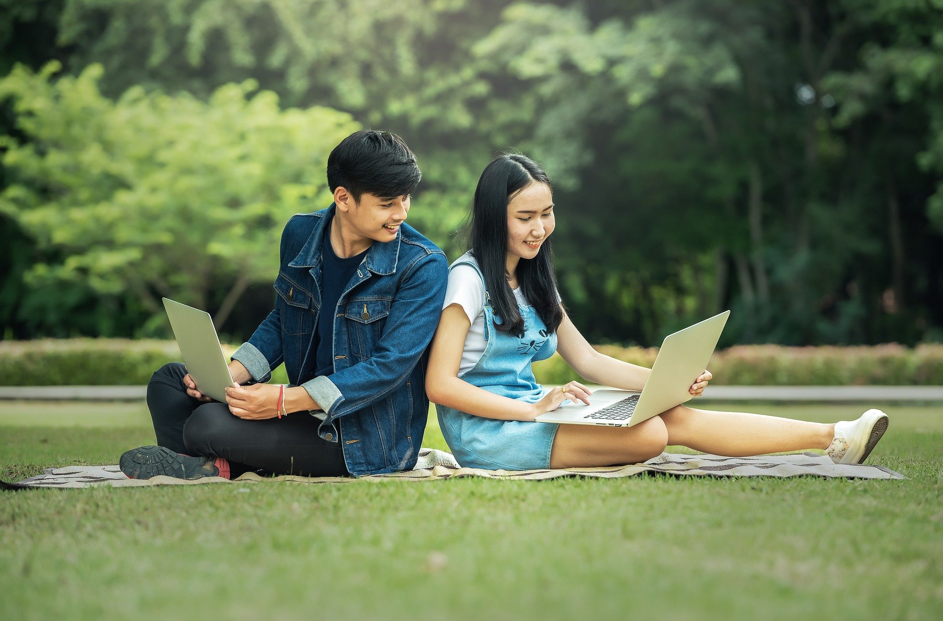 Teenagers studying together with laptops